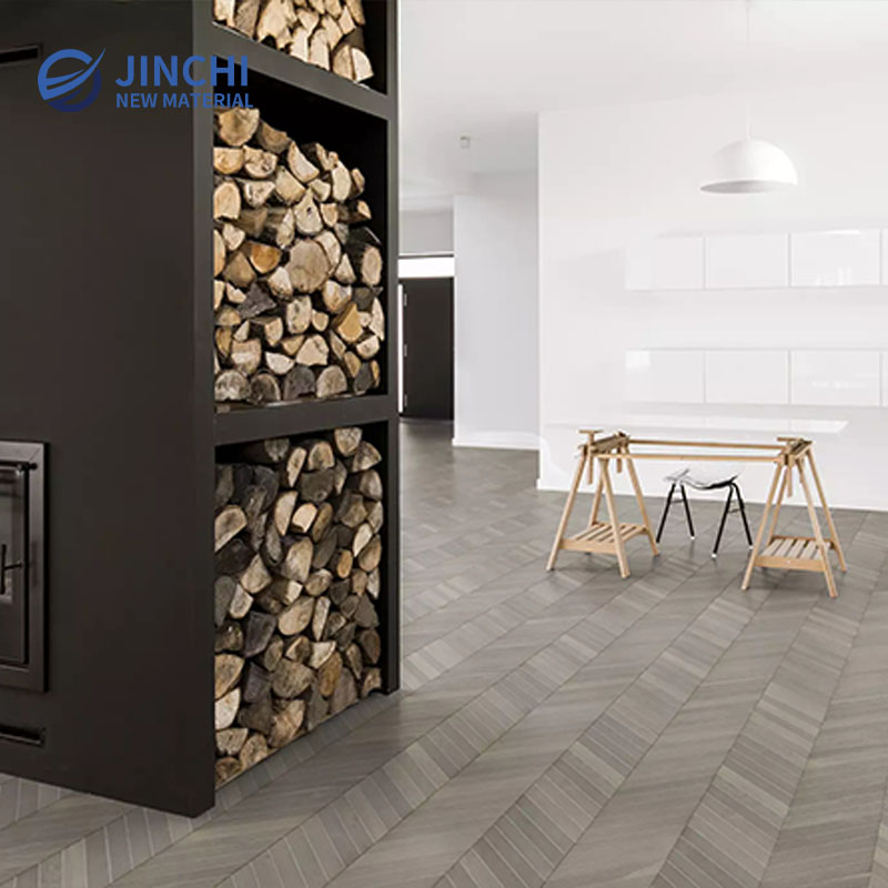 Pavimento in legno massello di rovere grigio chiaro con motivo a spina di pesce.