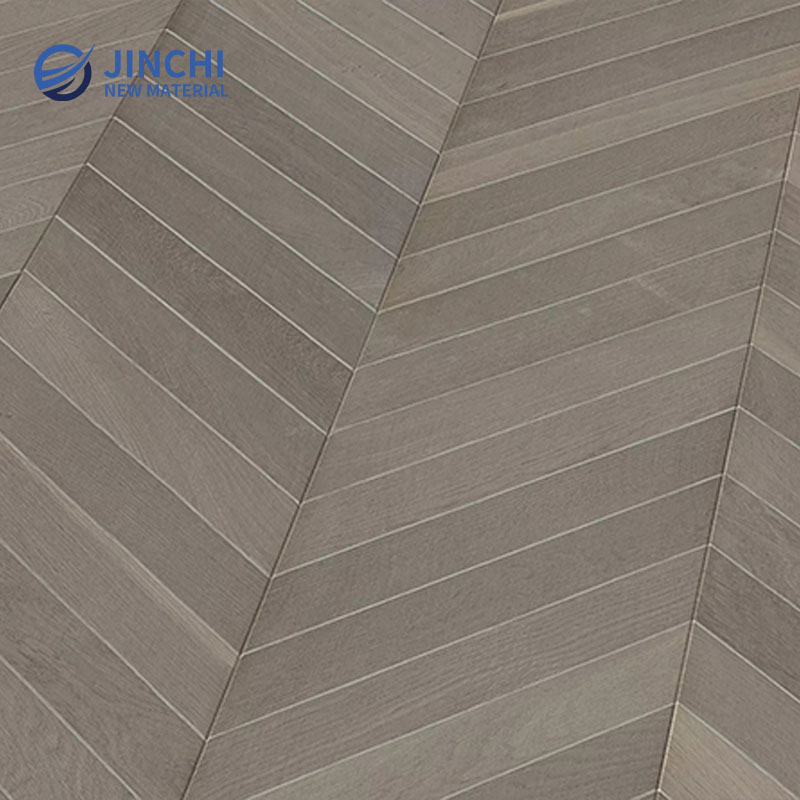 Pavimento in legno massello di rovere grigio chiaro con motivo a spina di pesce.